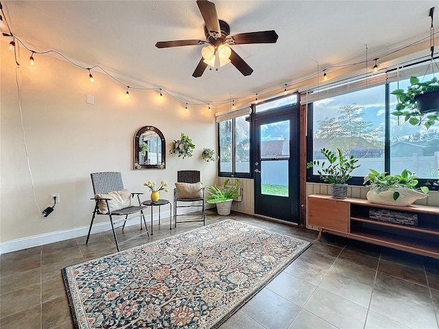 sitting room with tile patterned flooring, a ceiling fan, and baseboards