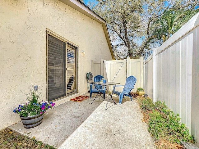 view of patio with fence and a gate