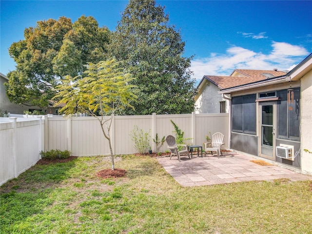 view of yard with a patio area, a fenced backyard, and a sunroom