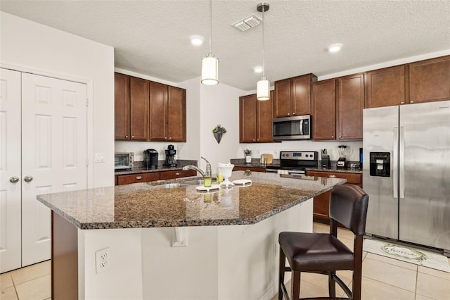 2817 Noble Crow Dr, Kissimmee, FL 34744 - kitchen with pendant lighting, a breakfast bar area, light tile patterned flooring, a sink, and stainless steel appliances