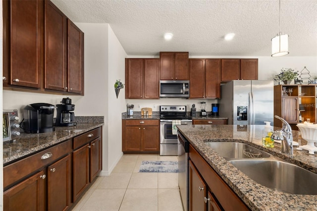 2817 Noble Crow Dr, Kissimmee, FL 34744 - kitchen with light tile patterned floors, a sink, pendant lighting, a textured ceiling, and appliances with stainless steel finishes