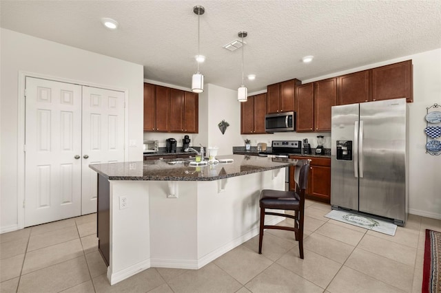 2817 Noble Crow Dr, Kissimmee, FL 34744 - kitchen with light tile patterned flooring, a sink, dark stone countertops, stainless steel appliances, and a kitchen island with sink