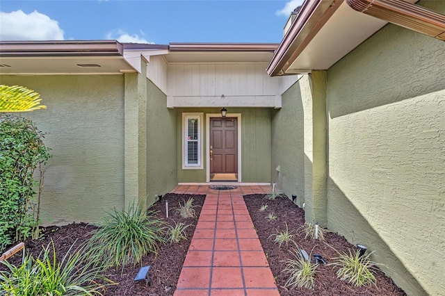 view of exterior entry with stucco siding