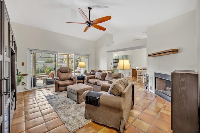 living area with a ceiling fan, a fireplace, and high vaulted ceiling