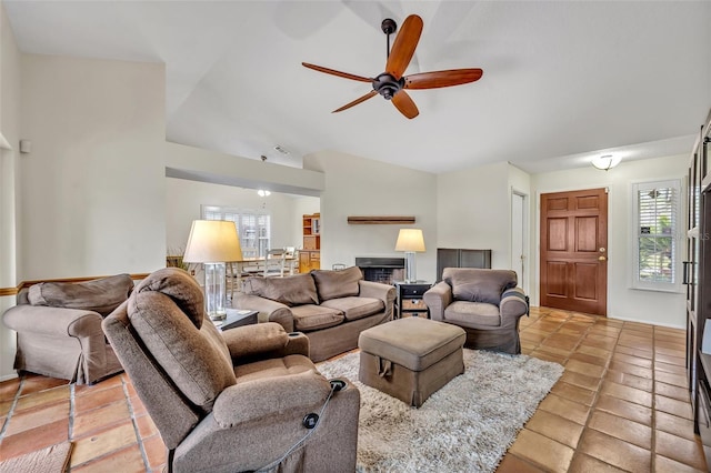 living room with lofted ceiling, ceiling fan, and light tile patterned floors