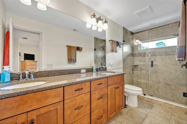 bathroom with visible vents, a sink, a shower stall, and toilet