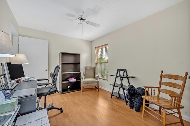 office area with light wood finished floors, baseboards, and a ceiling fan