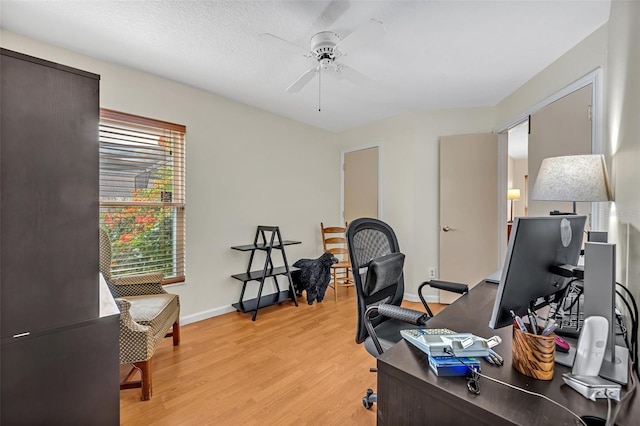 office area featuring a ceiling fan, light wood-type flooring, and baseboards