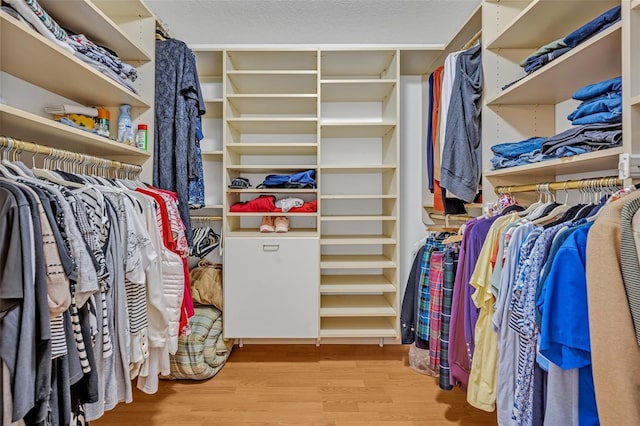 walk in closet with wood finished floors