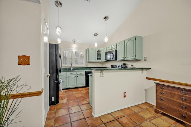 kitchen featuring dark countertops, a peninsula, vaulted ceiling, black appliances, and green cabinetry