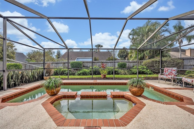 view of pool with a patio, glass enclosure, a fenced backyard, and a pool with connected hot tub