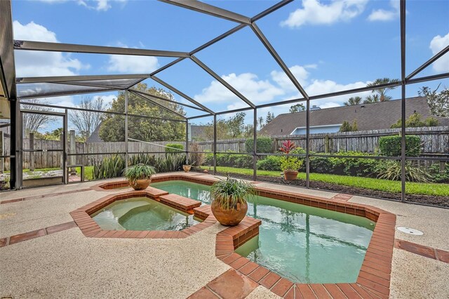 view of swimming pool featuring a patio, a fenced backyard, a pool with connected hot tub, and a lanai