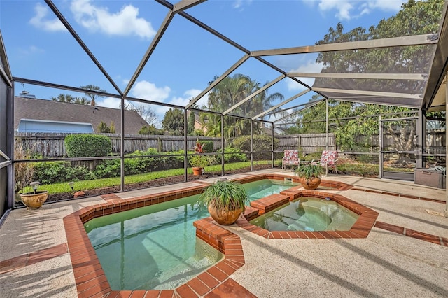 view of pool with glass enclosure, a patio area, a fenced backyard, and a pool with connected hot tub