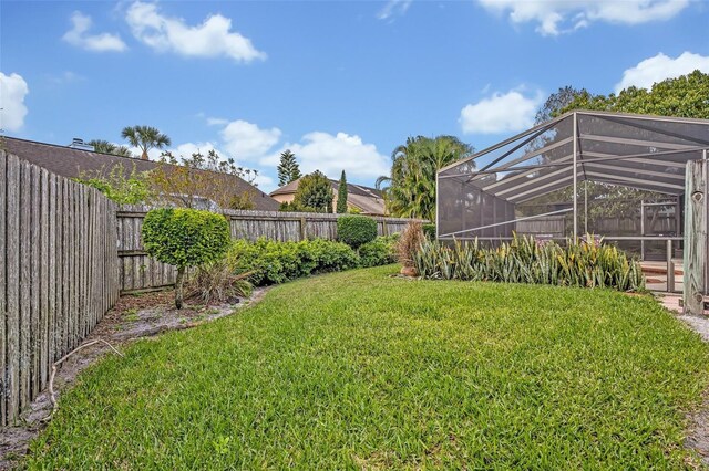 view of yard featuring a lanai and a fenced backyard