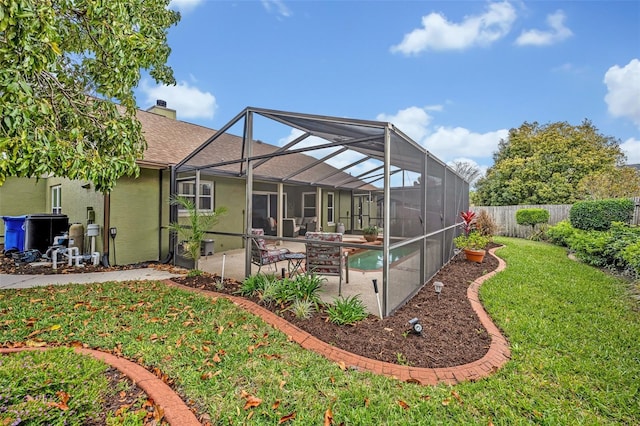 rear view of property featuring a yard, a chimney, stucco siding, a patio area, and a fenced backyard