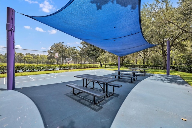 view of home's community featuring community basketball court and fence