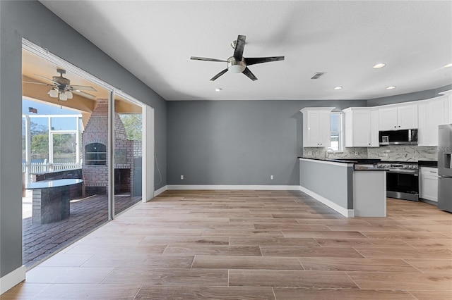 kitchen featuring stainless steel appliances, white cabinetry, visible vents, decorative backsplash, and dark countertops