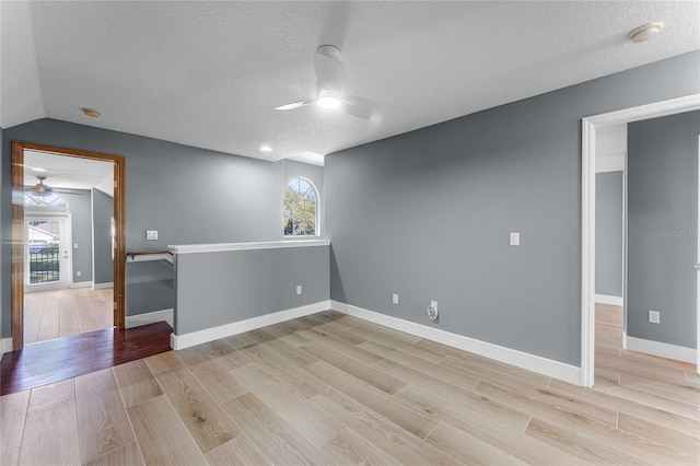 empty room with light wood-type flooring, ceiling fan, and a wealth of natural light