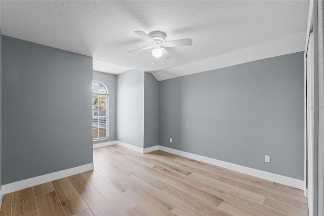 empty room featuring light wood-style floors, a textured ceiling, baseboards, and a ceiling fan