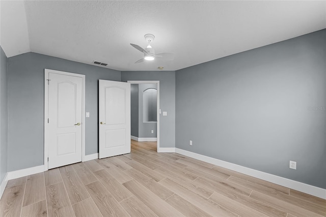 unfurnished bedroom with a textured ceiling, a ceiling fan, visible vents, baseboards, and light wood-type flooring