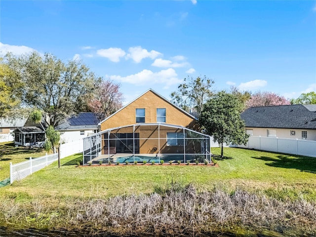 back of property with a fenced in pool, a lanai, a fenced backyard, and a lawn