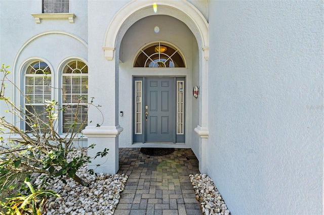 doorway to property featuring stucco siding