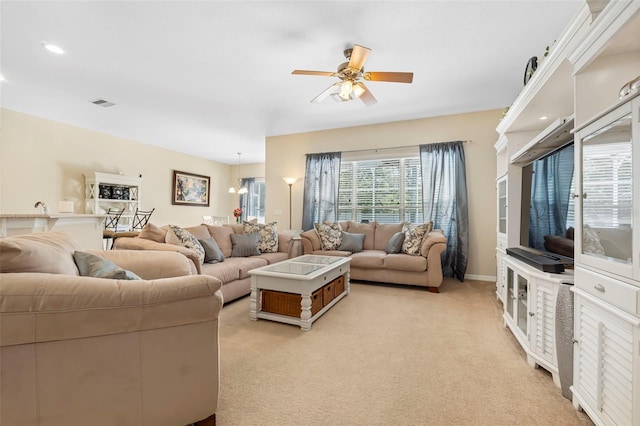 living room with light carpet, ceiling fan, visible vents, and baseboards