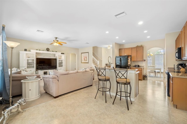 living room with a ceiling fan, arched walkways, visible vents, and recessed lighting