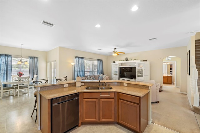 kitchen featuring dishwasher, open floor plan, arched walkways, and a sink