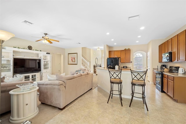 living room featuring visible vents, stairs, arched walkways, and recessed lighting