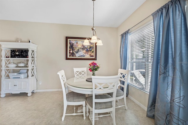 dining area with a chandelier, baseboards, and tile patterned floors