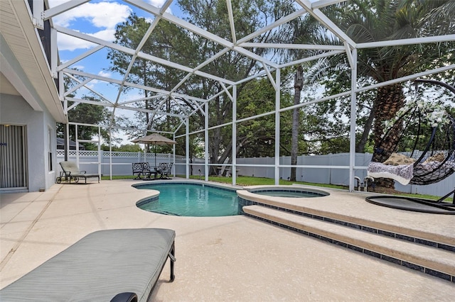 view of swimming pool with a pool with connected hot tub, a lanai, a fenced backyard, and a patio