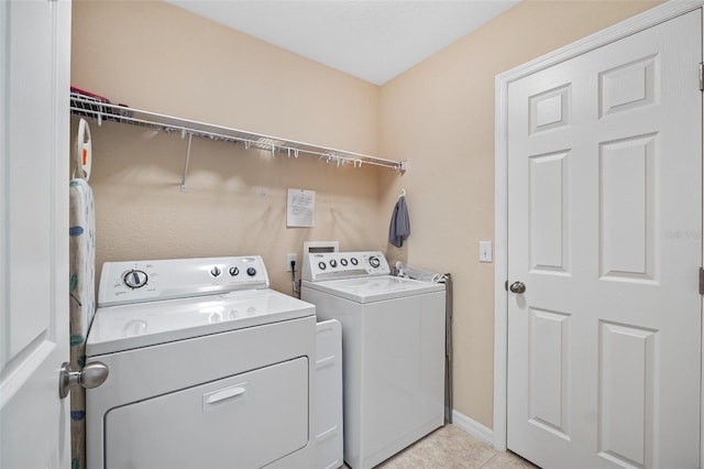 laundry room featuring light tile patterned floors, laundry area, independent washer and dryer, and baseboards