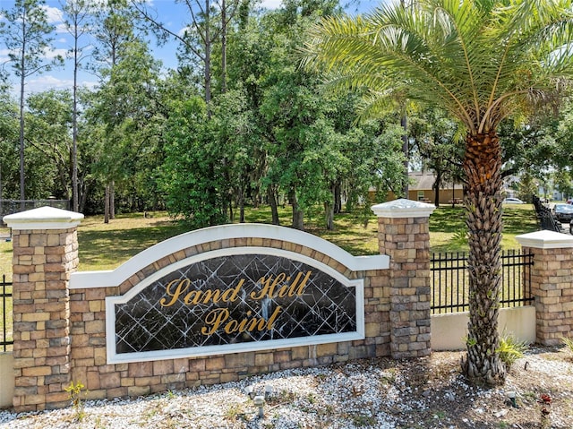 community / neighborhood sign featuring fence