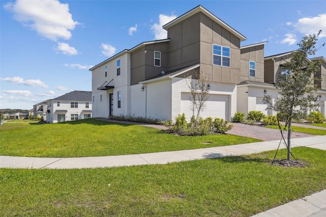 contemporary home featuring stucco siding, a residential view, an attached garage, decorative driveway, and a front yard