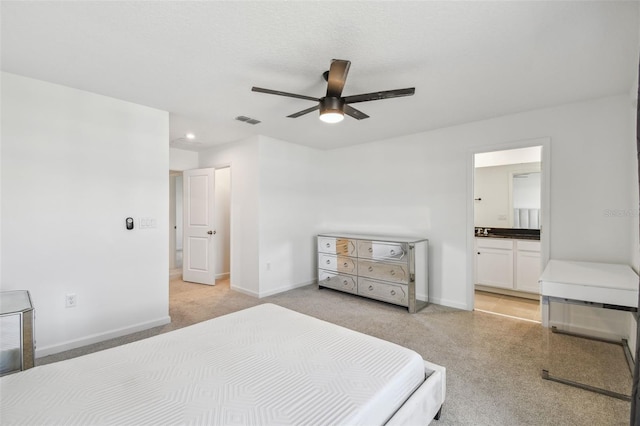 bedroom featuring visible vents, ceiling fan, baseboards, and ensuite bathroom