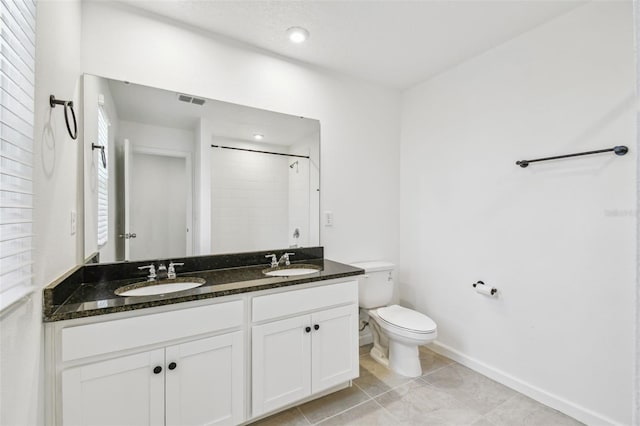 bathroom featuring toilet, visible vents, a shower, and a sink