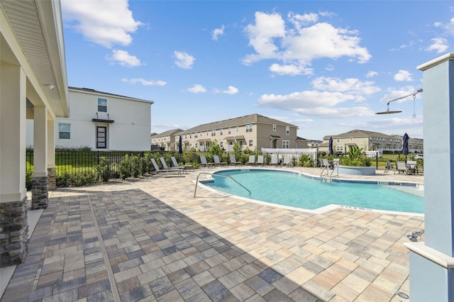 pool featuring a patio area, a residential view, and fence