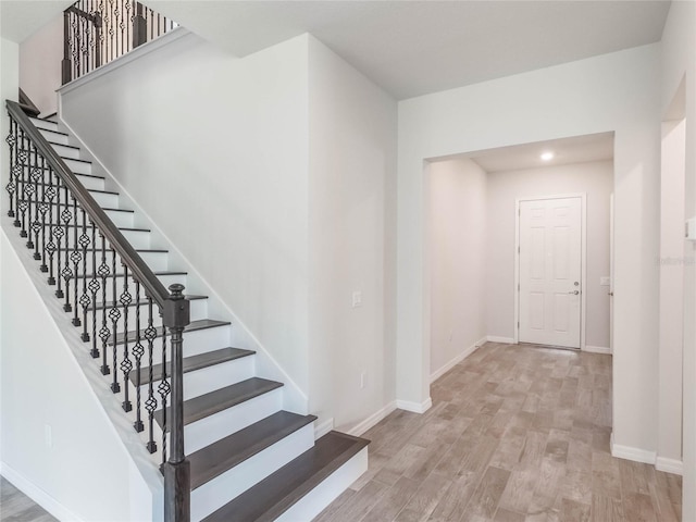 stairs with recessed lighting, baseboards, and wood finished floors