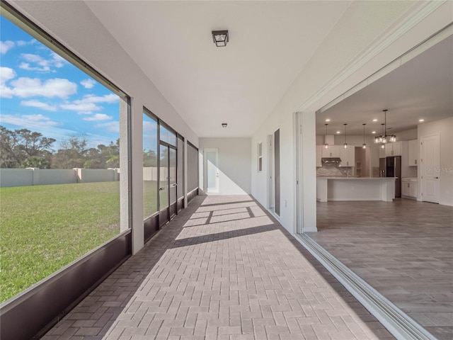 unfurnished sunroom with an inviting chandelier