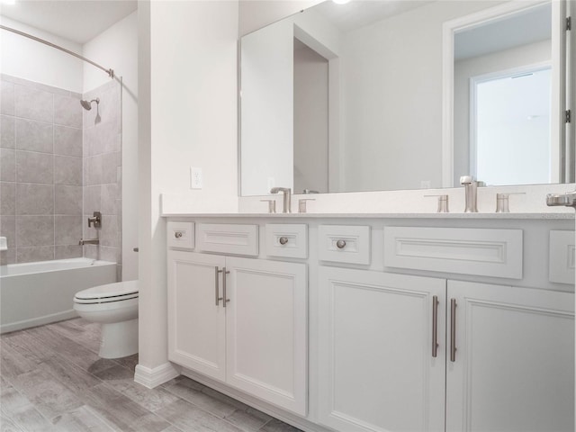 full bath featuring double vanity, wood finished floors, toilet, and a sink