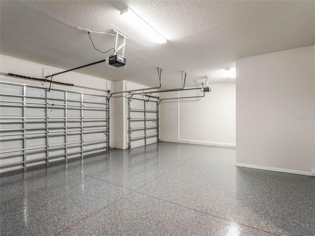 garage featuring a garage door opener and baseboards