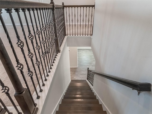 stairs with wood finished floors and baseboards