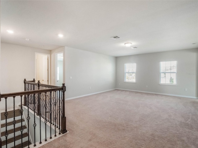 carpeted empty room featuring visible vents, recessed lighting, and baseboards