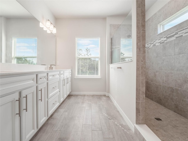 full bath featuring a healthy amount of sunlight, vanity, walk in shower, and wood finished floors