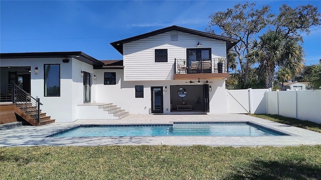 back of house featuring a fenced in pool, fence, stucco siding, a balcony, and a patio area