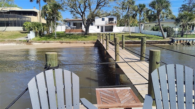 dock area featuring fence and a water view