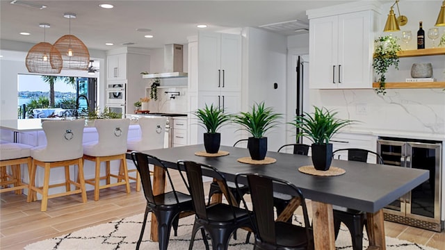 dining space featuring recessed lighting, light wood-style floors, and beverage cooler