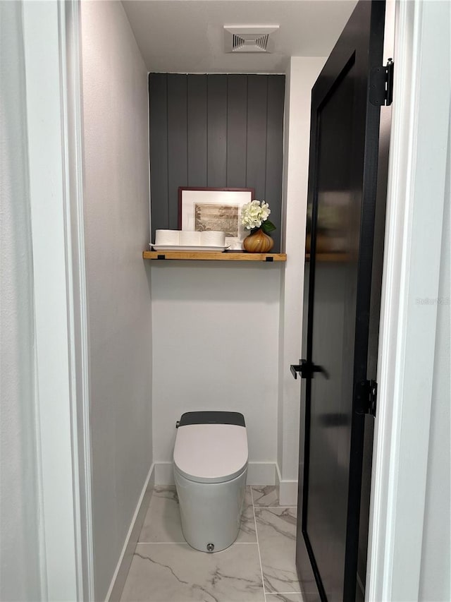 bathroom featuring toilet, baseboards, visible vents, and marble finish floor