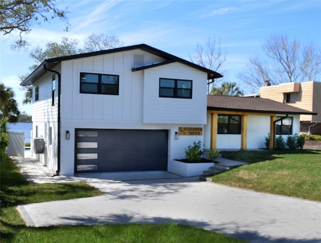 view of front of home with brick siding, board and batten siding, a front yard, a garage, and driveway